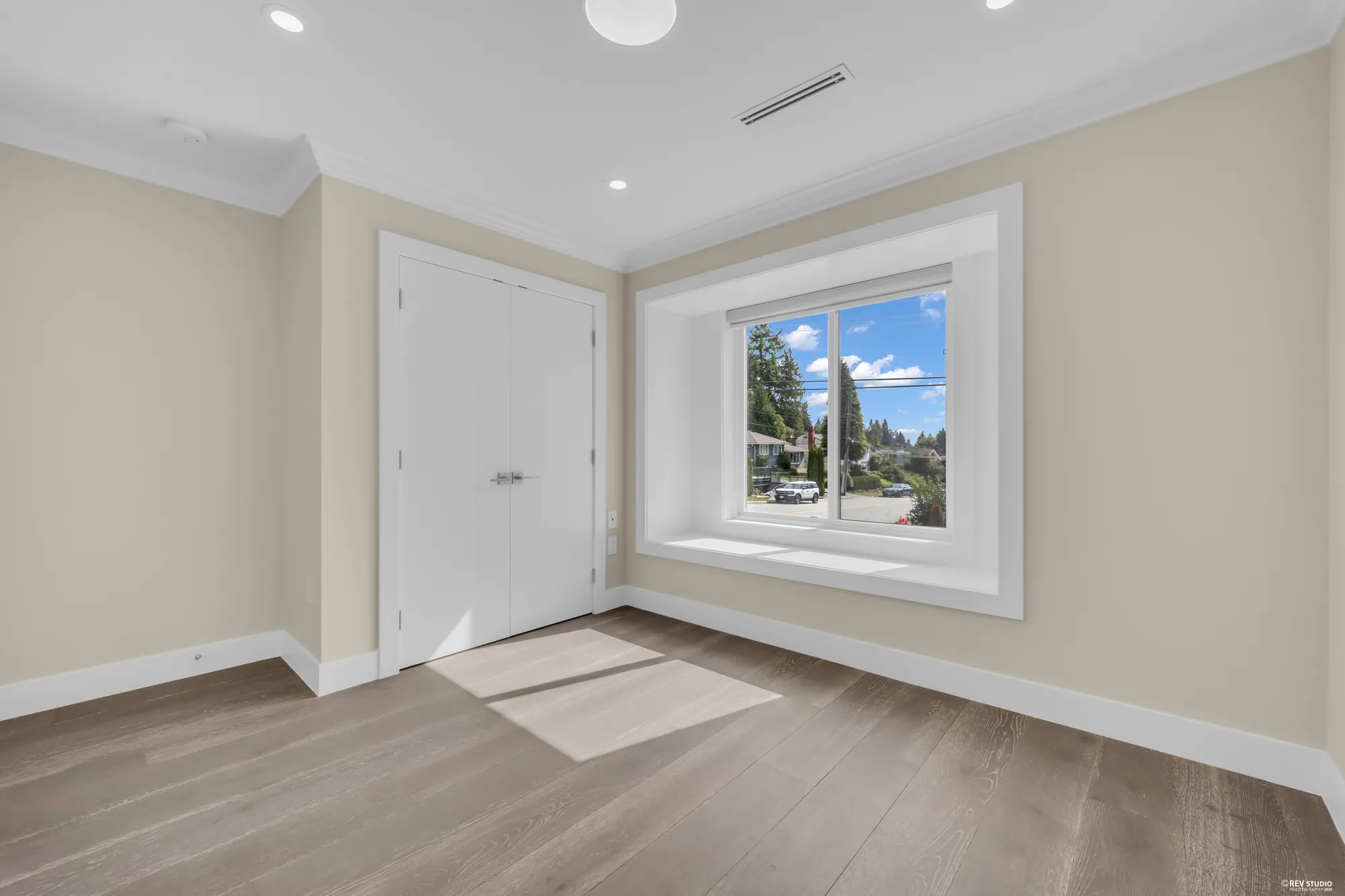 A bedroom with a closet and a window onto the street
