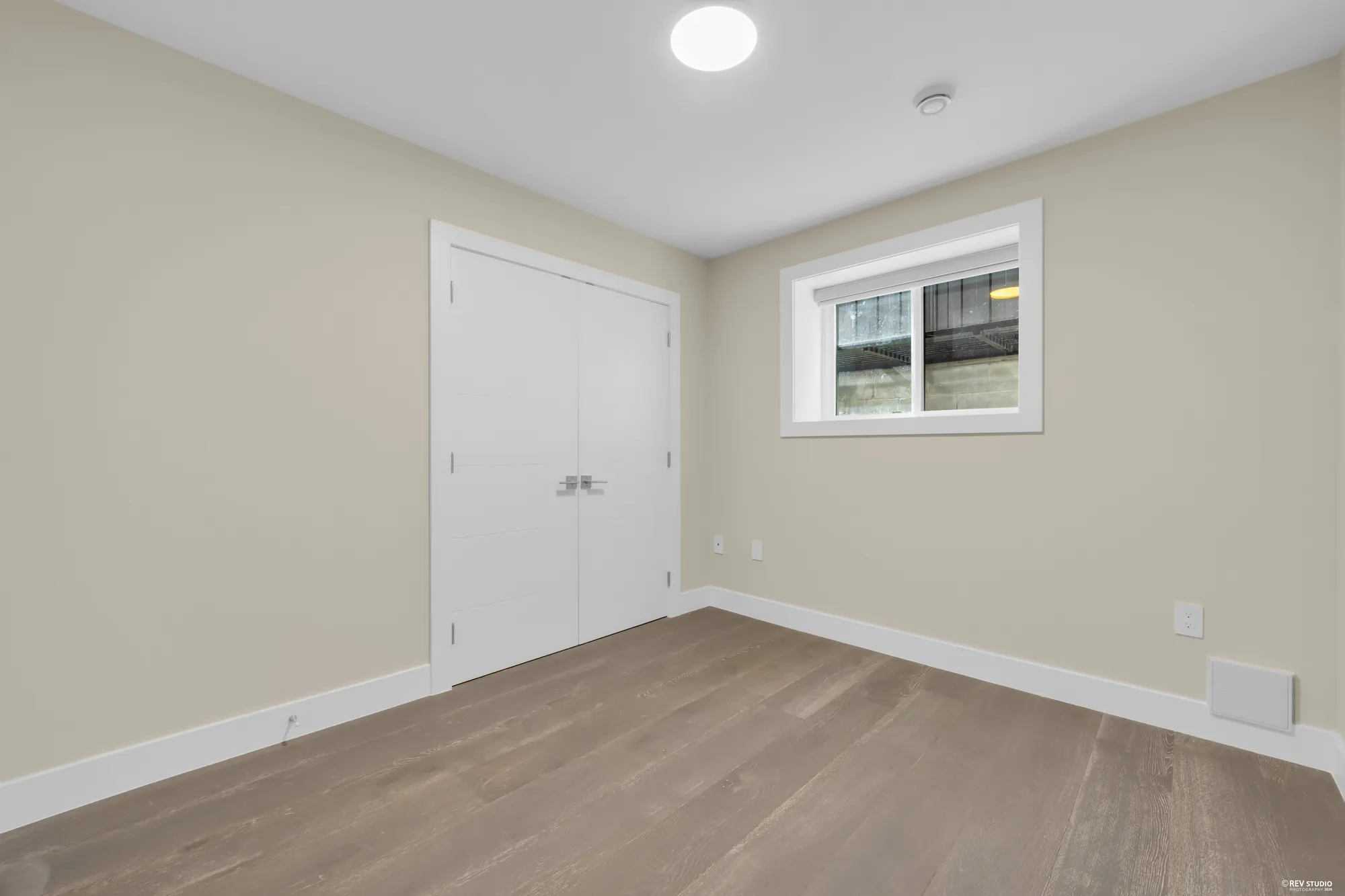 A lower bedroom with a double closet and a window