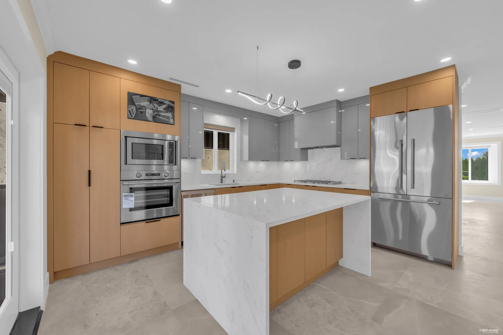 The island and the tall oak run with the wall ovens, the fridge on the right