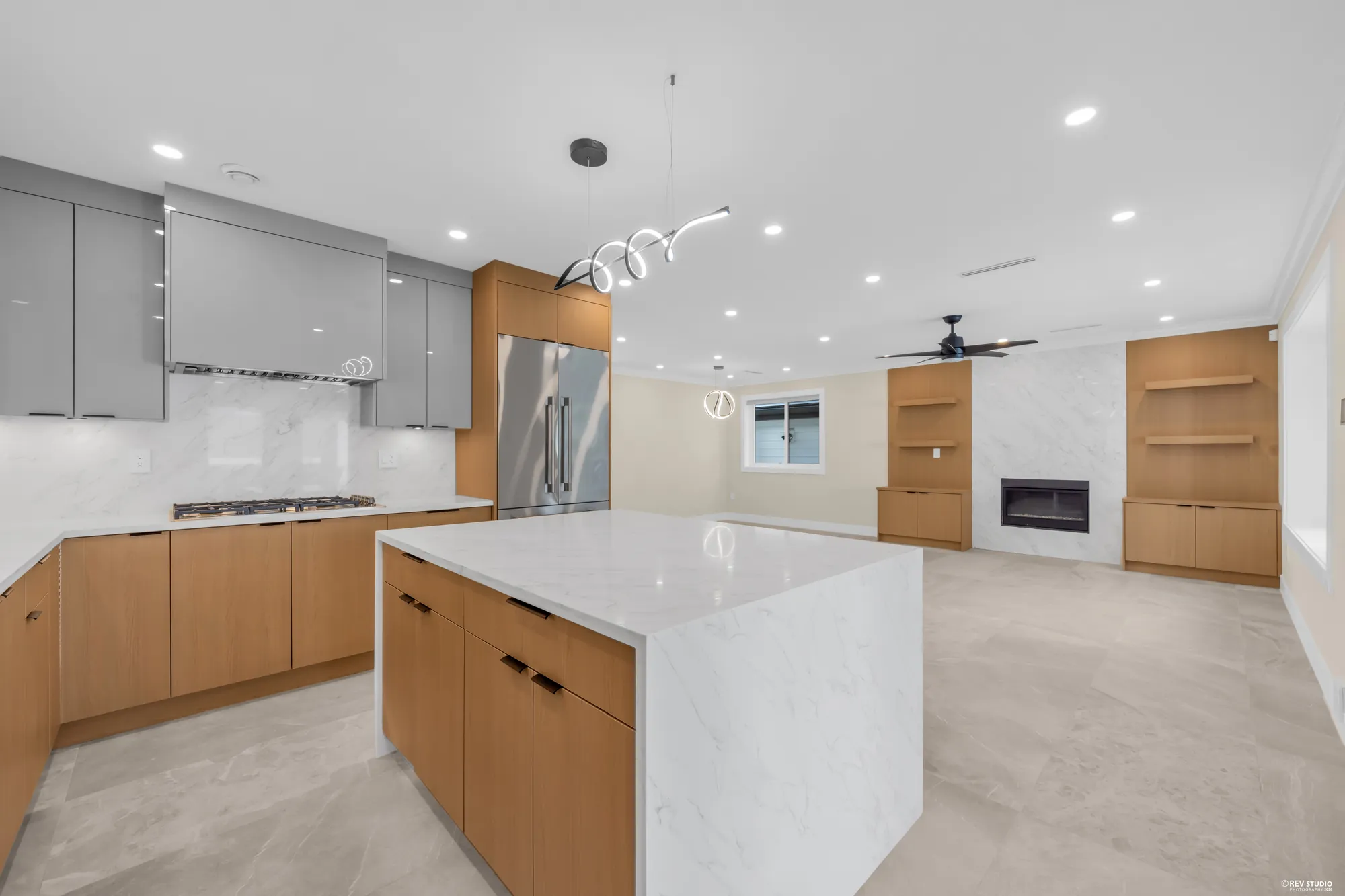 The kitchen from the counter, the range under its hood, the island and the family room beyond