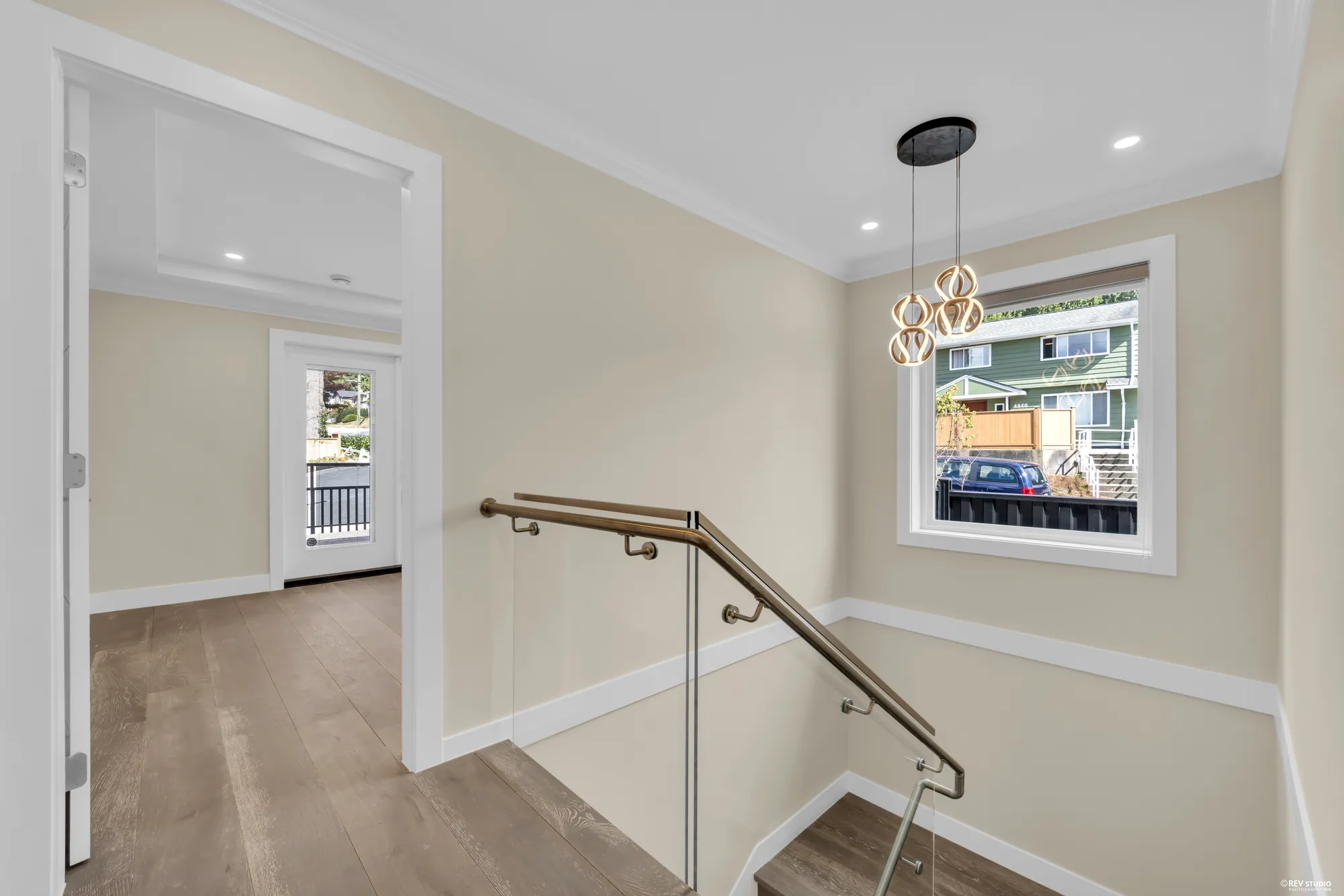 The landing at the top of the stair, a pendant light and a window