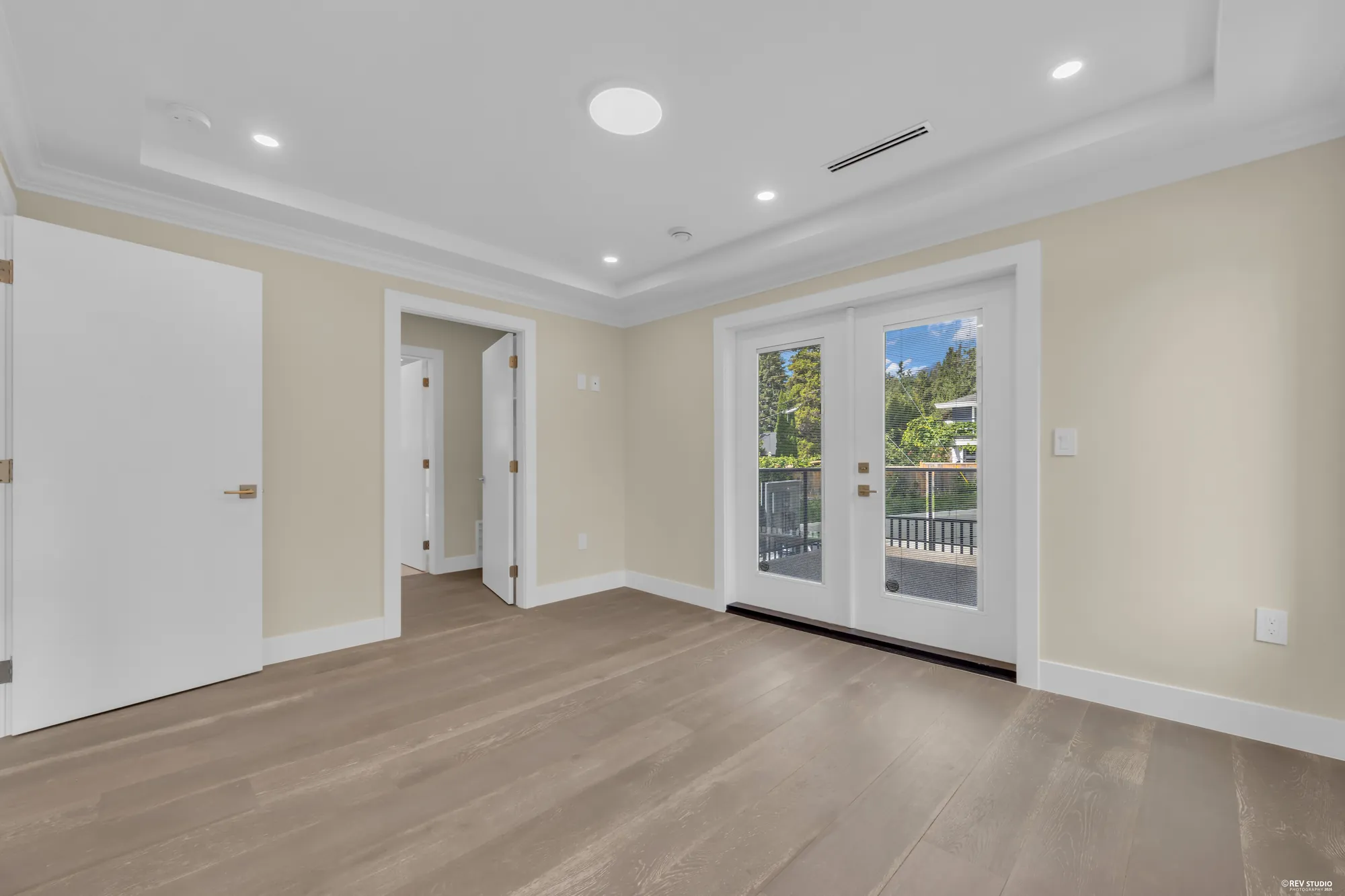 The primary bedroom toward its door, the walk-in closet and the bathroom beyond
