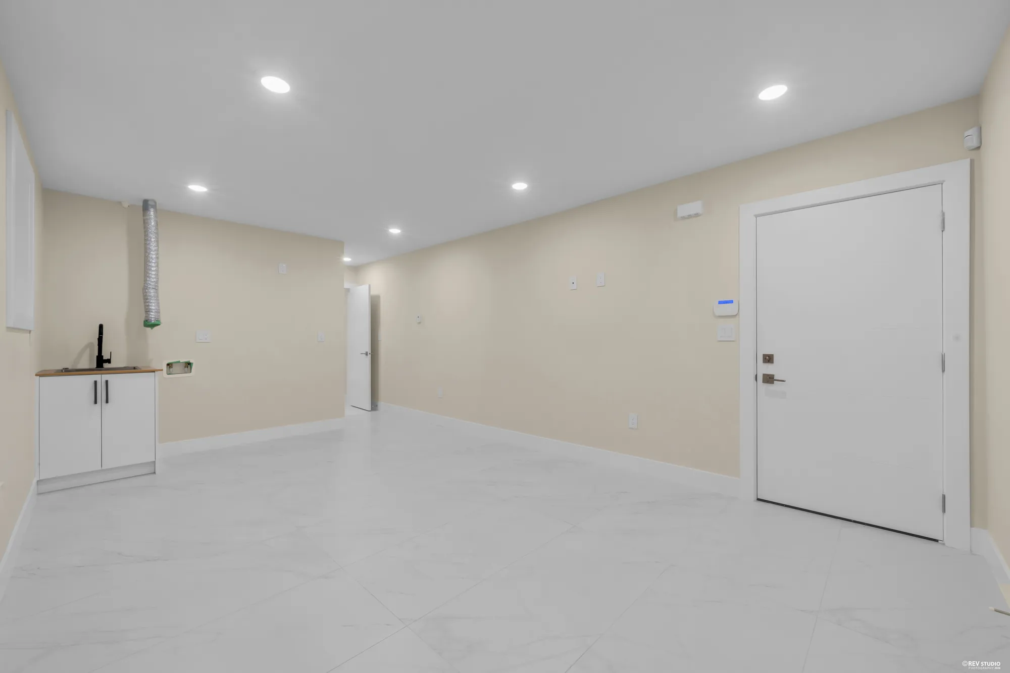 The recreation room toward the hall, the bar cabinet on the left