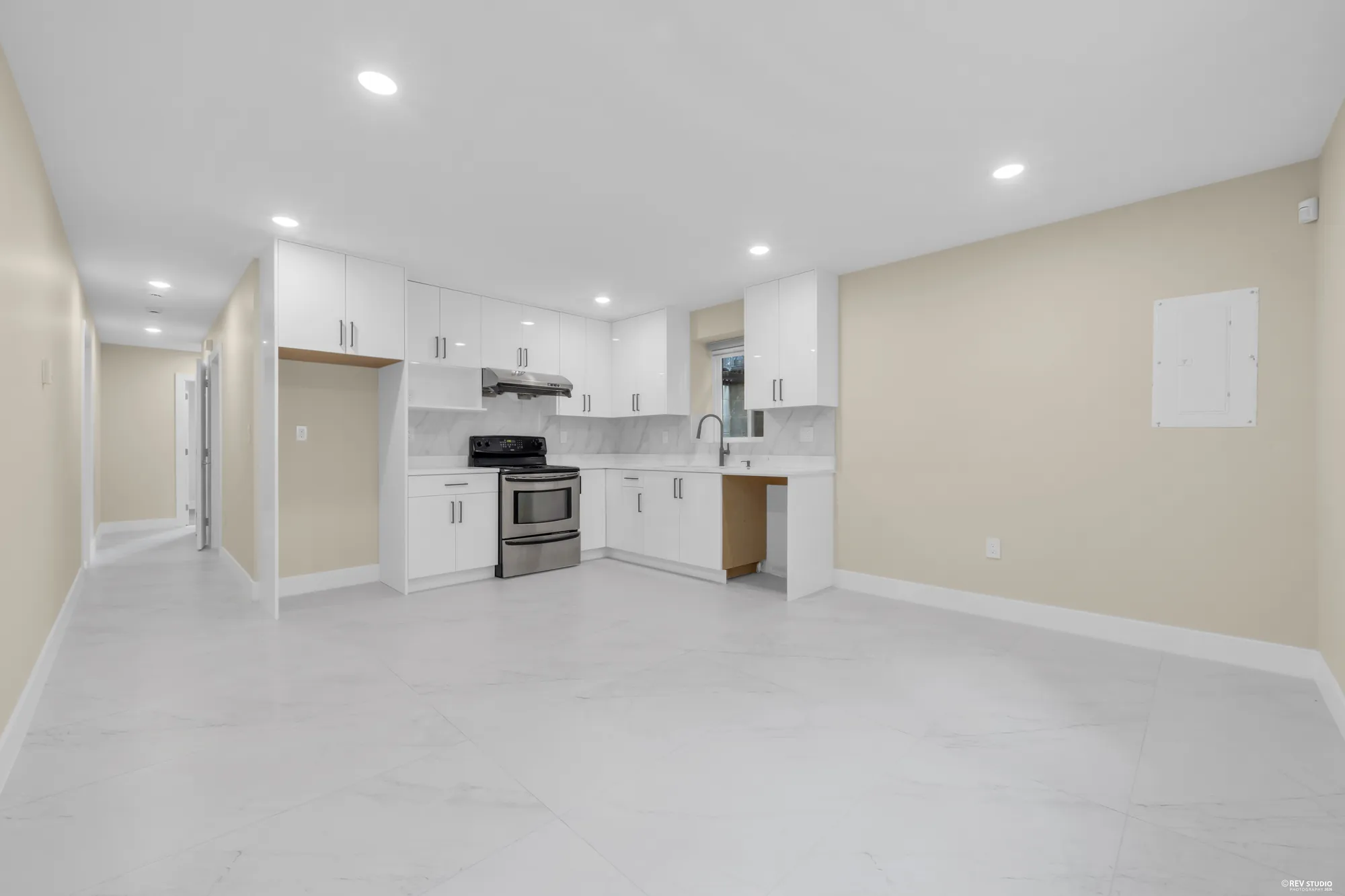 The lower kitchen and the living area beside it, tiled throughout